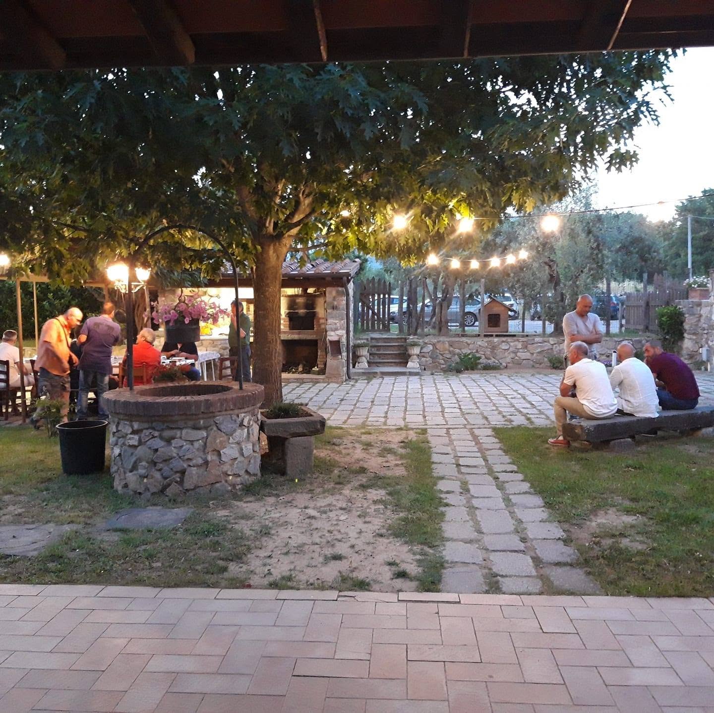 Cortile con pozzo e ospiti al tramonto
