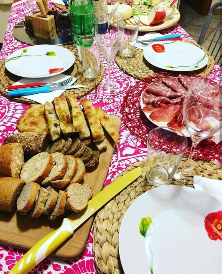 Tavola apparecchiata con pane e salumi