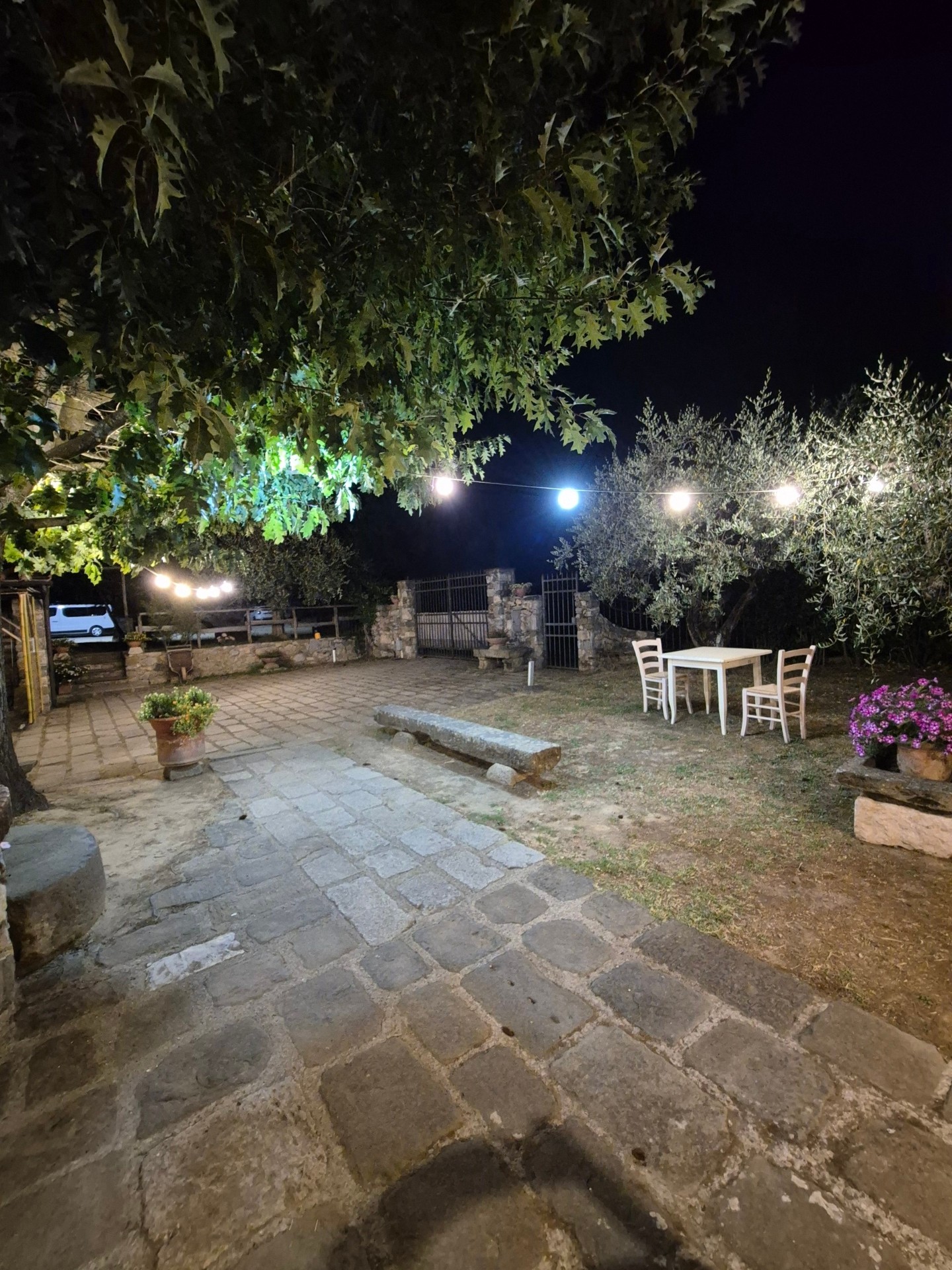 Cortile in pietra con tavolo apparecchiato di sera